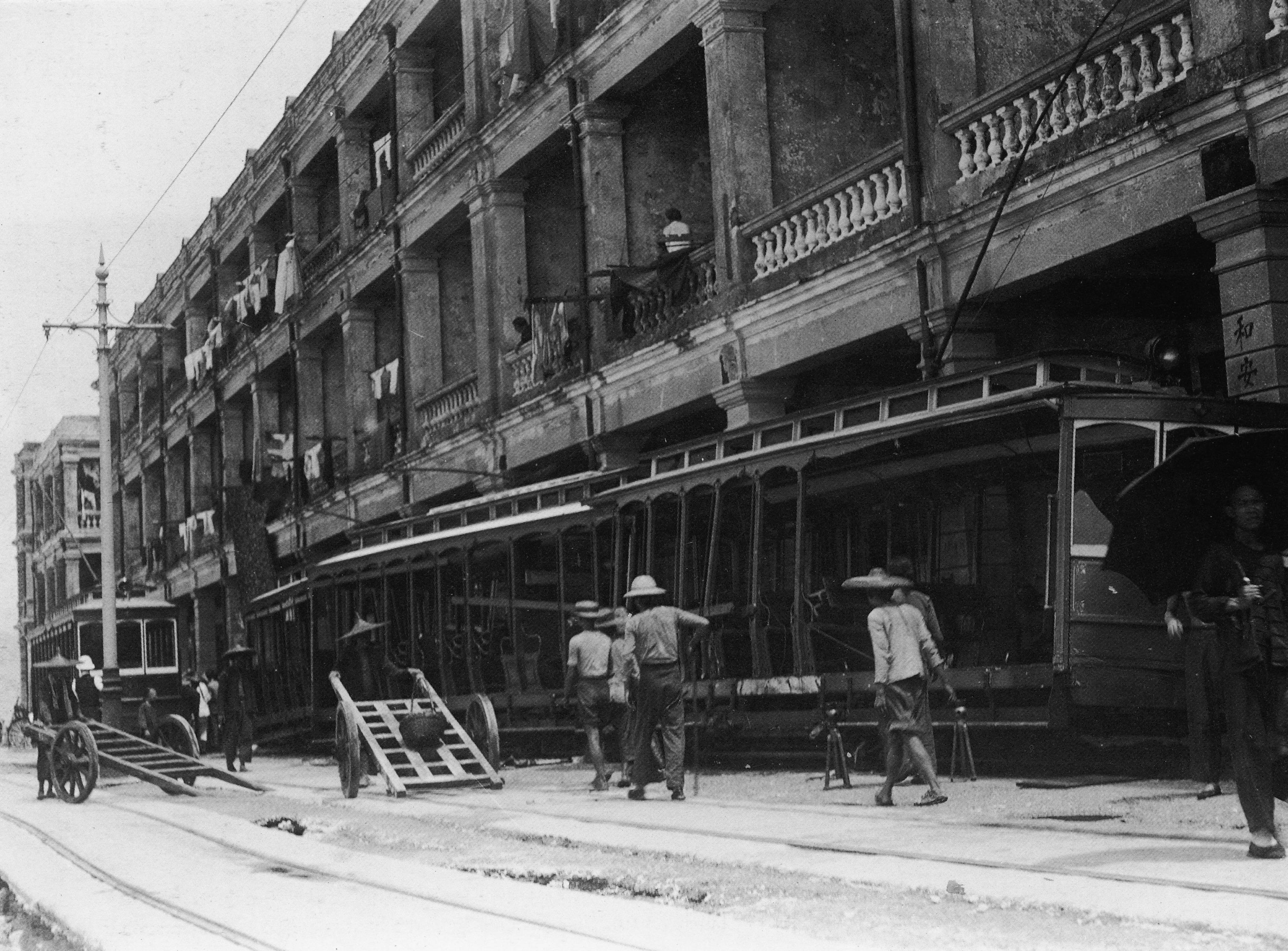 1906年毀滅性颶風後的石塘咀堅尼地城海旁與皇后大道西交界，電車後的屋宇是稱為「石騎樓」的下級娼寮。（圖片來源：鄭寶鴻提供）